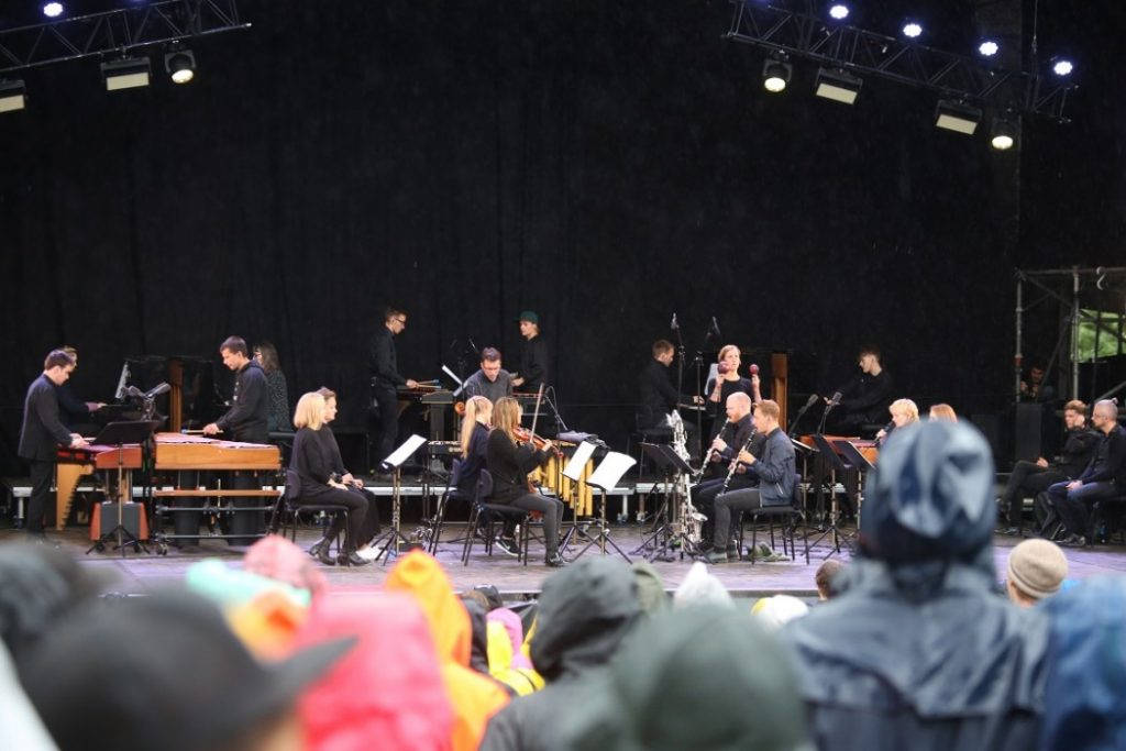 Musikk for 18 musikere gjennom regnet. Foto: Erik Valebrokk